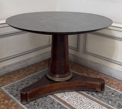 une table ronde avec un piètement en bois dans une pièce