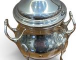 a silver pot with a lid on a stand