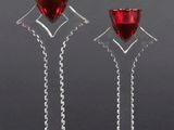 a pair of wine glasses with red wine in them on a black background