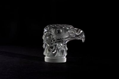 a glass sculpture of an eagle on a black surface