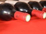 several bottles of wine are lined up on a red table