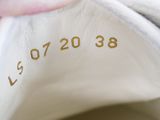 a close up of a pair of white shoes with gold numbers on them
