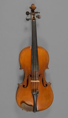 an old violin with a bow hanging on a wall