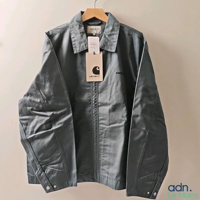 a close up of a jacket hanging on a hanger on a wall