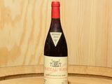 une bouteille de vin posée sur un tonneau en bois