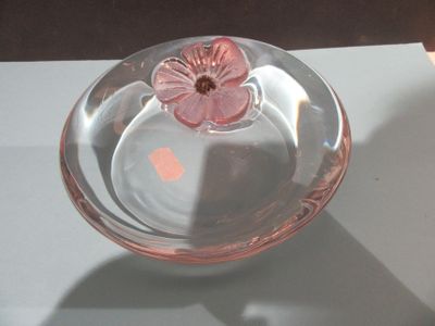 a glass bowl with a flower in it on a table