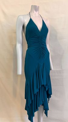 Le mannequin porte une robe vert sarcelle à volants.