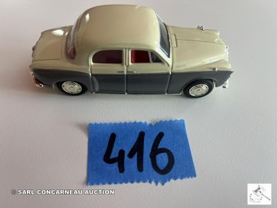 une petite voiture posée à côté d'une feuille de papier