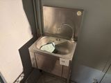 un lavabo dans un coin de la salle de bains, avec une serviette dessus