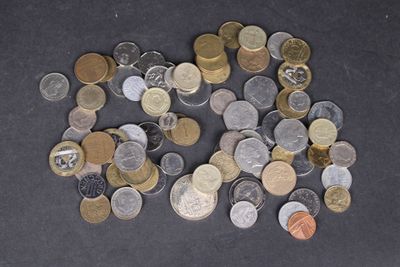 un tas de pièces posé sur une table, sur fond noir
