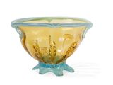 a yellow and blue glass bowl sitting on a white surface