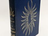 a blue book with a gold sun on the cover