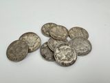 a pile of silver coins sitting on top of a white surface