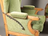 pair of green upholstered chairs with wooden arms and arms