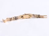 an image of a gold bracelet on a white surface