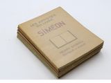 un vieux livre posé sur une table à côté d'une pile de livres