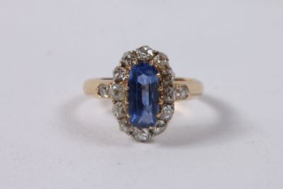 gros plan d'une bague en saphir bleu et diamant sur une surface blanche