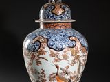 a large vase with a bird on top of it