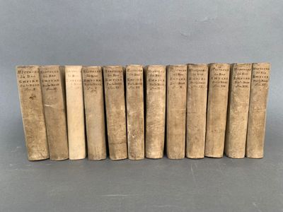 six vieux livres alignés sur une surface grise