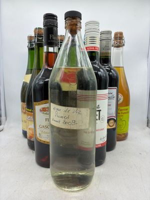 Des bouteilles de vin sont alignées sur une table devant un fond blanc.