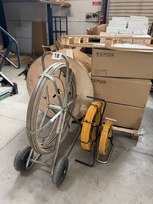 un chariot sur lequel sont empilées des boîtes et un tuyau, dans un entrepôt