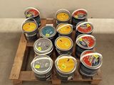 many cans of paint sitting on a pallet on the floor
