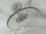 a wine glass with a stem on a white table