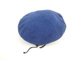 a blue hat on a white surface with a black cord