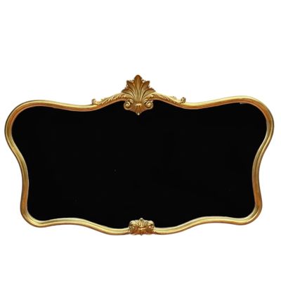 un miroir à cadre noir et doré, avec un cadre doré