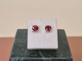 a pair of pink cubicge earrings on top of a marble block