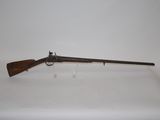 a rifle on a white surface with a wooden handle