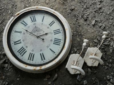 a clock that is sitting on the ground next to some wires
