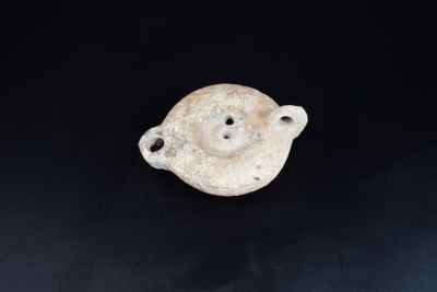 une image représentant un petit objet en céramique blanche posé sur une surface noire