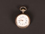 une vieille montre de poche avec des chiffres romains sur fond noir