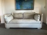 a couch that is sitting in a room with a painting on the wall