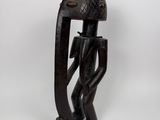une sculpture en bois représentant un homme à la grosse tête et au long nez