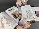 several books are open on a table with drawings and pictures
