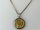 a necklace with a gold coin on a gold chain