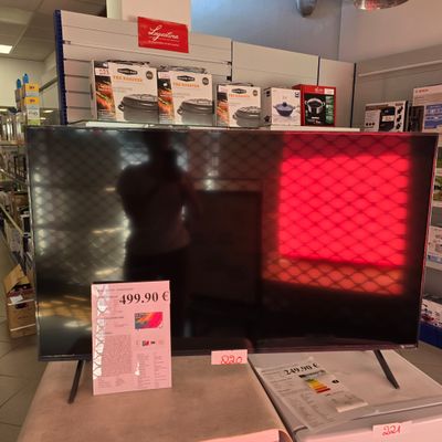 un grand téléviseur posé sur une table dans un magasin