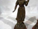 pair of antique bronze figurines of a woman holding a torch