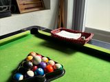 a pool table with balls on it and a basket of balls on the table