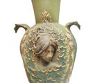 a green vase with a woman ' s face on it