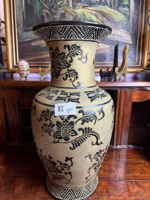 a large vase sitting on a table in front of a painting