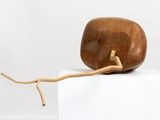 a wooden sculpture on top of a white box