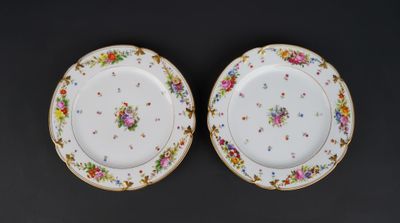 two plates with floral designs on them on a black surface