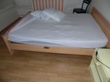 a bed with a wooden frame and a white sheet on it