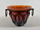 a red and black bowl sitting on a white surface