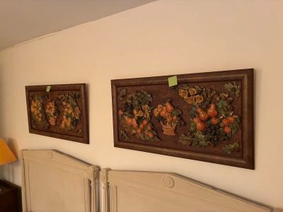 deux tableaux accrochés au mur au-dessus d'un lit dans une chambre à coucher