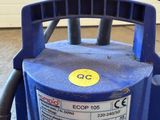 a blue blower sitting on the floor in front of a garage door