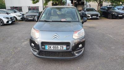 La voiture est garée sur le parking, à côté de nombreuses autres voitures.